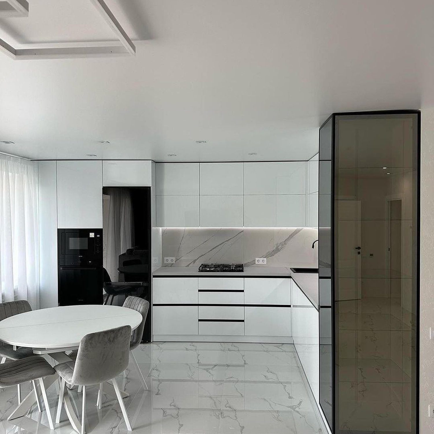 Modern minimalist kitchen with sleek white cabinetry and black accents