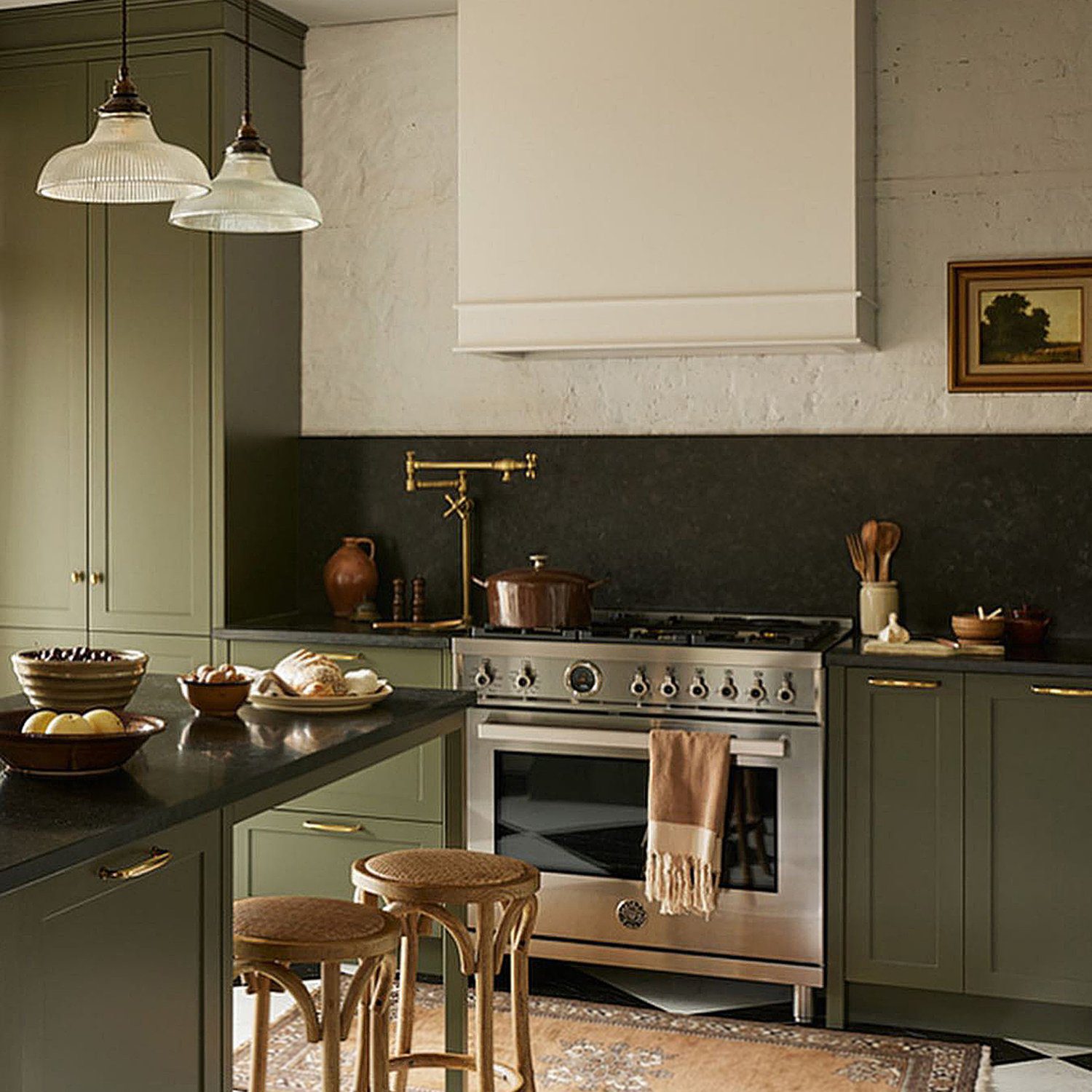 A tastefully designed kitchen with olive green cabinetry and brass fixtures