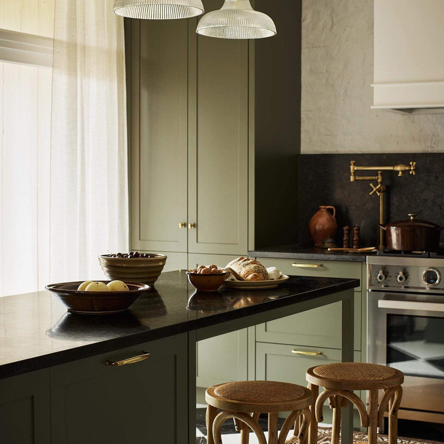 A tastefully designed kitchen space with olive green cabinetry