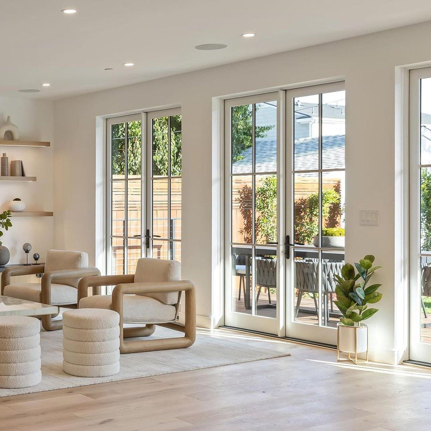 Stylish and modern living room with large French doors opening to an outdoor dining area