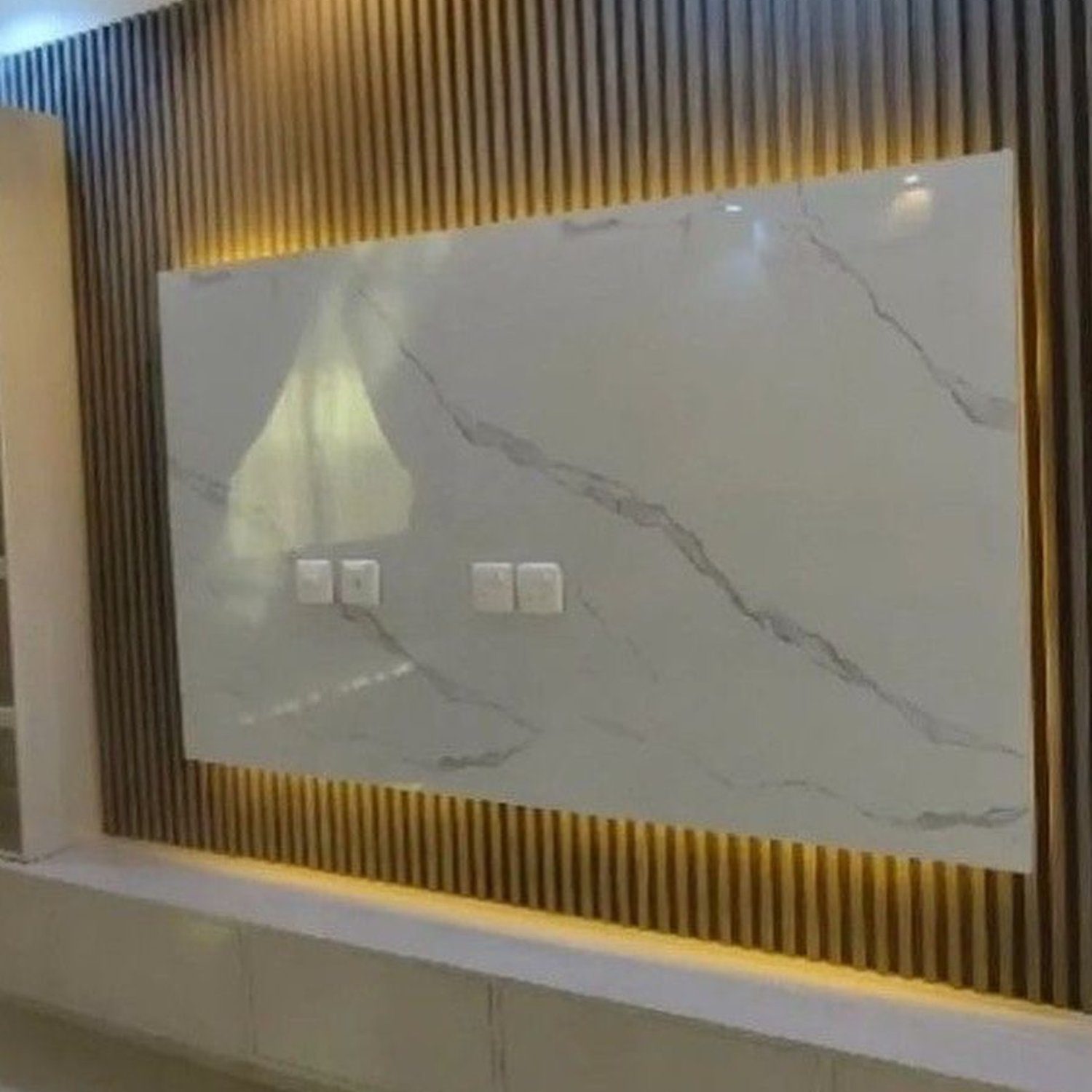 A modern and elegant recessed wall niche featuring a marble panel and LED lighting