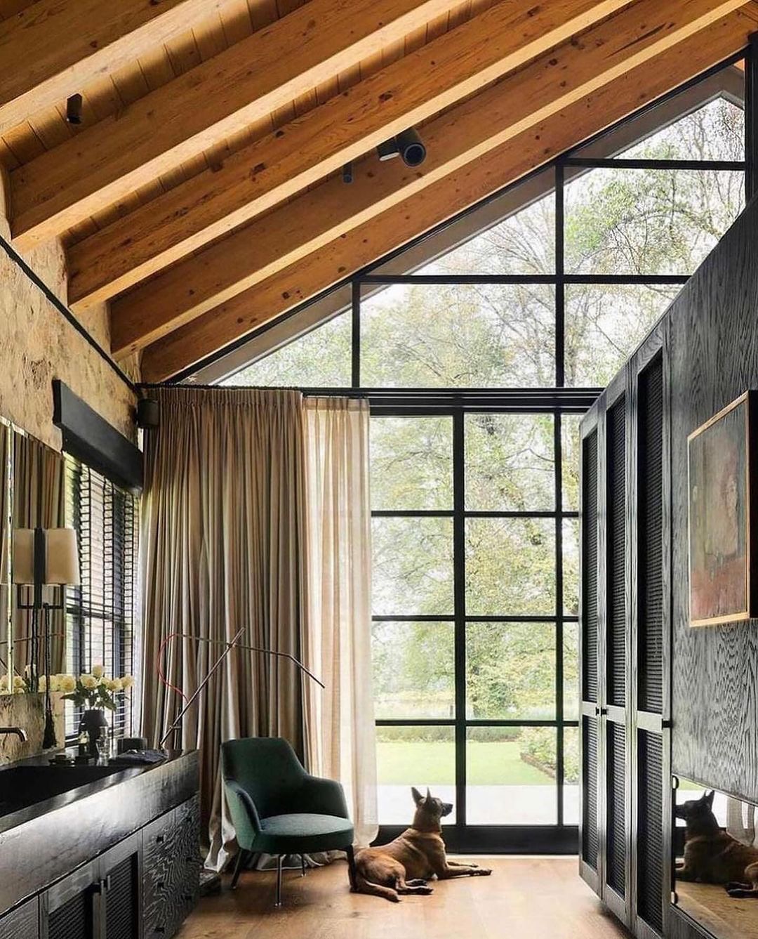 A modern rustic living room featuring expansive floor-to-ceiling windows