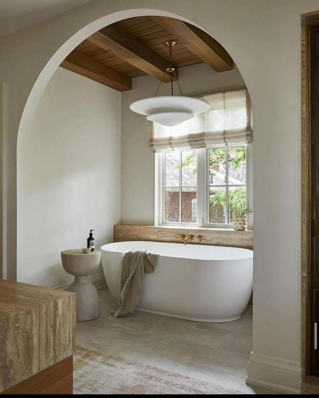 A tasteful and serene bathroom featuring a free-standing tub and natural tones