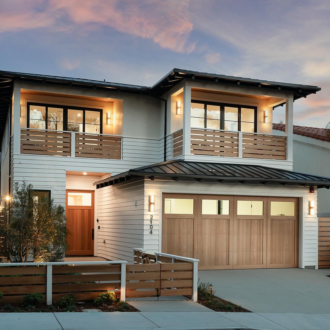 A modern two-story house featuring a balanced mix of wood, glass, and metal materials in its design