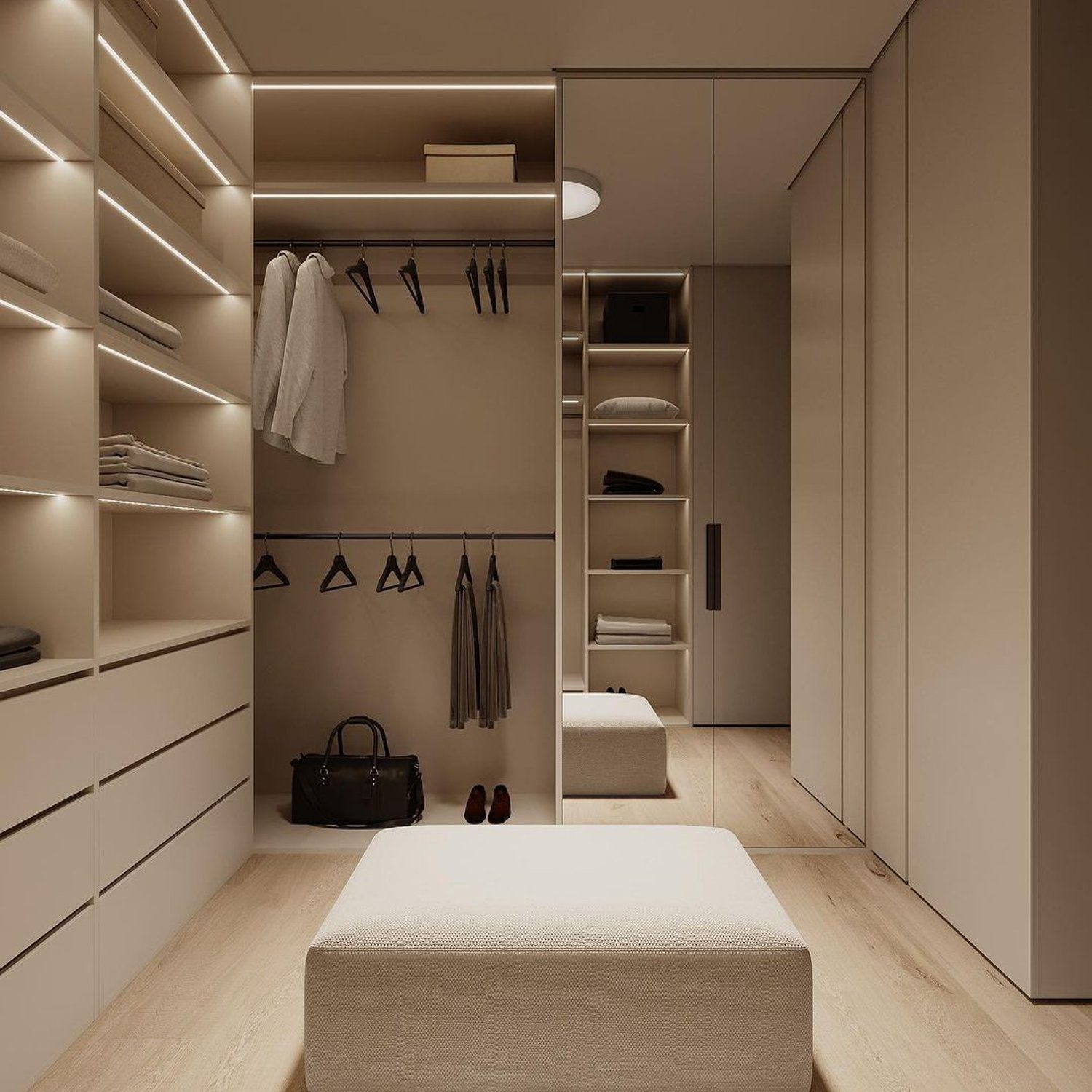 A meticulously organized walk-in closet with warm lighting highlighting the sleek built-in storage solutions and a comfortable seating area.