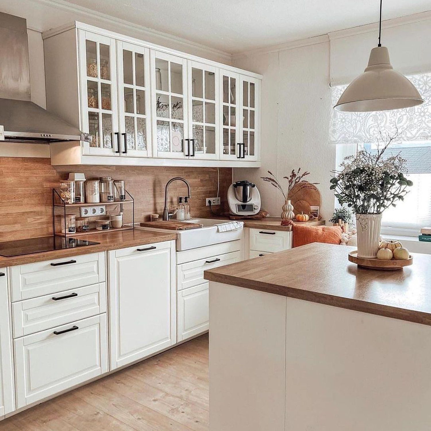 A modern kitchen with white cabinetry and wooden details.