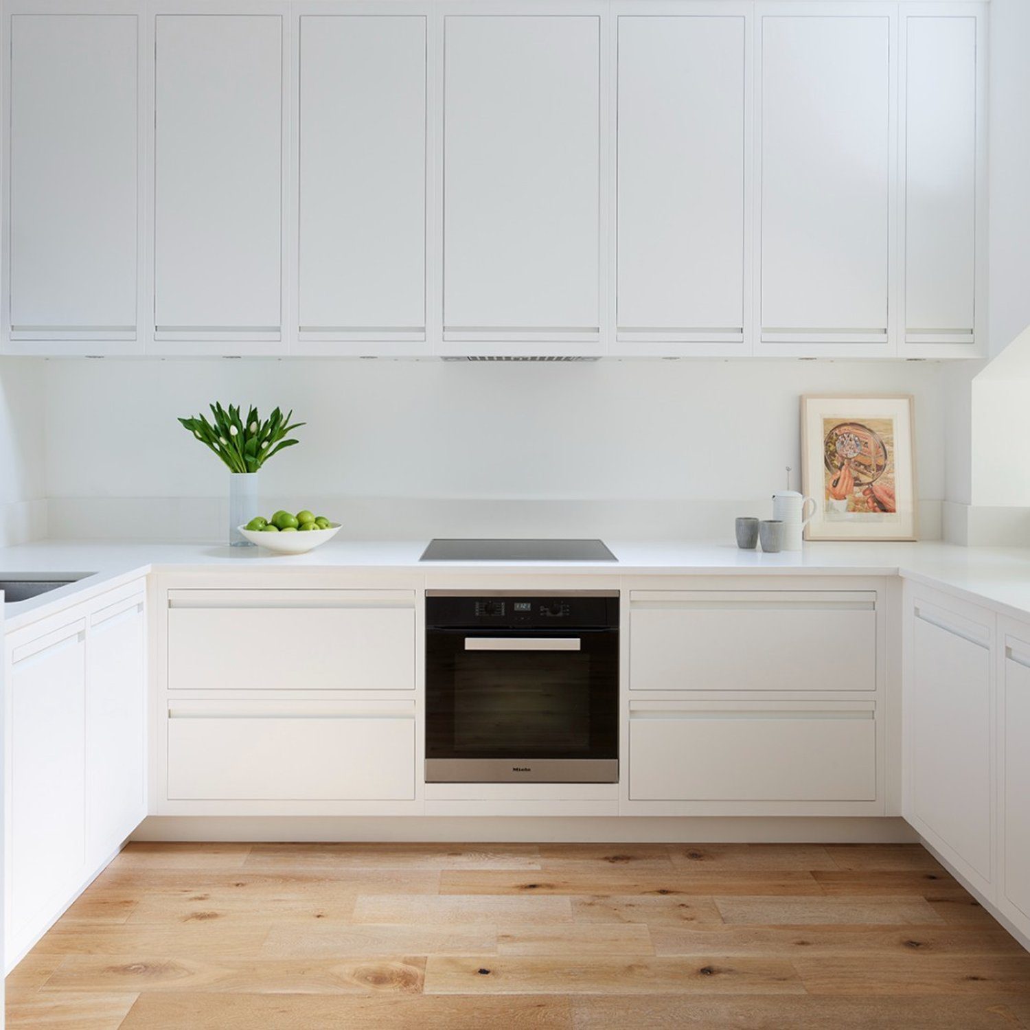 Modern white kitchen with hardwood floors