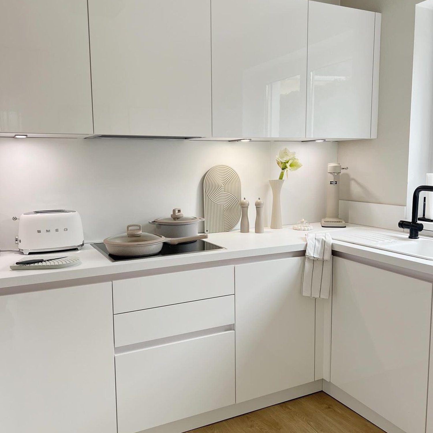 A modern and sleek kitchen design with white cabinetry