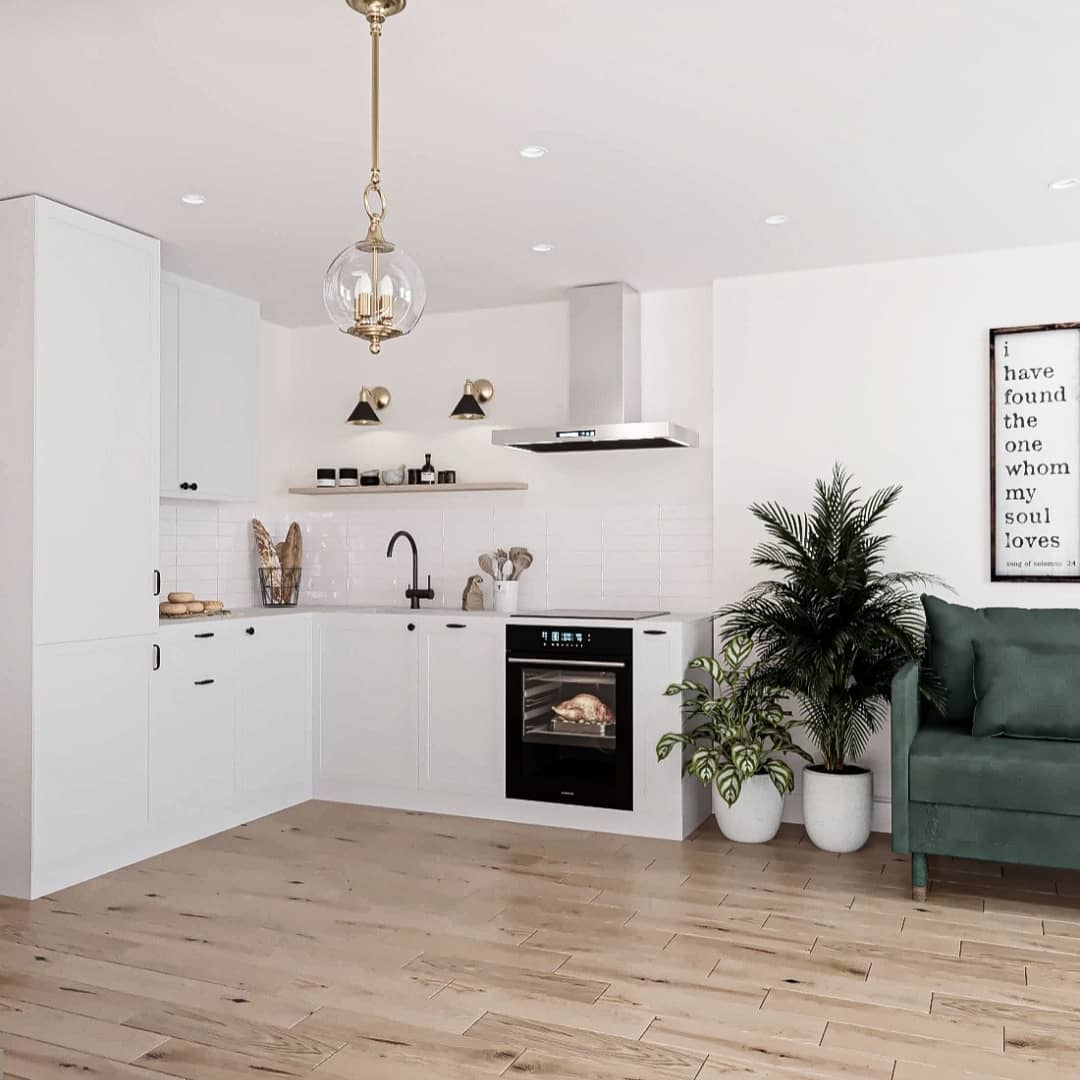 A chic and modern kitchen with crisp white cabinetry, herringbone wood flooring, and a vibrant green armchair adding a pop of color