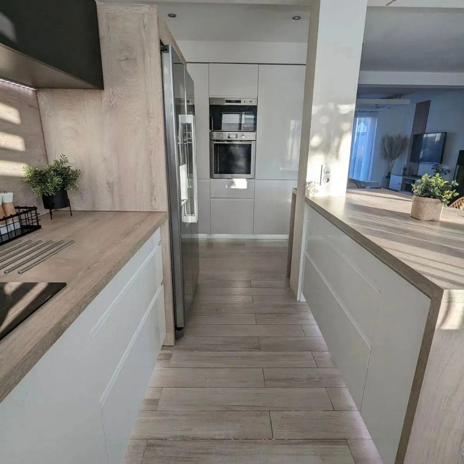 A sleek modern kitchen featuring wood grain cabinetry, integrated appliances, and a minimalist aesthetic