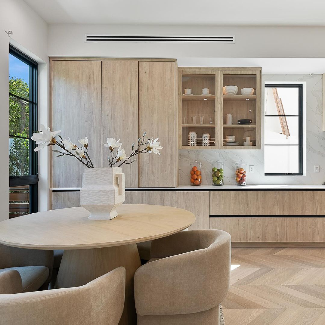 A modern kitchen with sleek wooden cabinets and open shelving, showcasing simple yet sophisticated design.