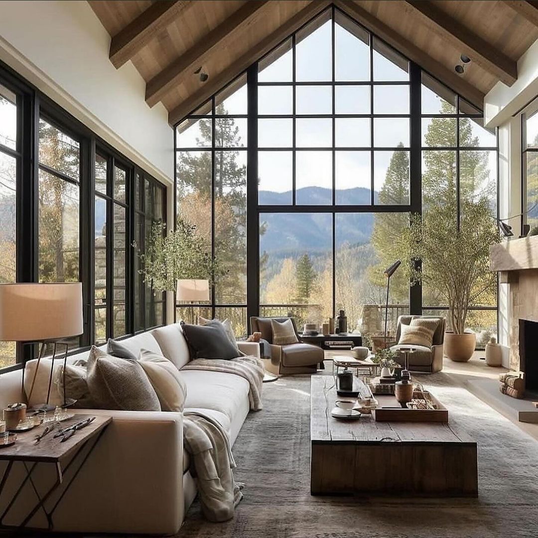 A modern mountain living space with expansive windows framing breathtaking forest views