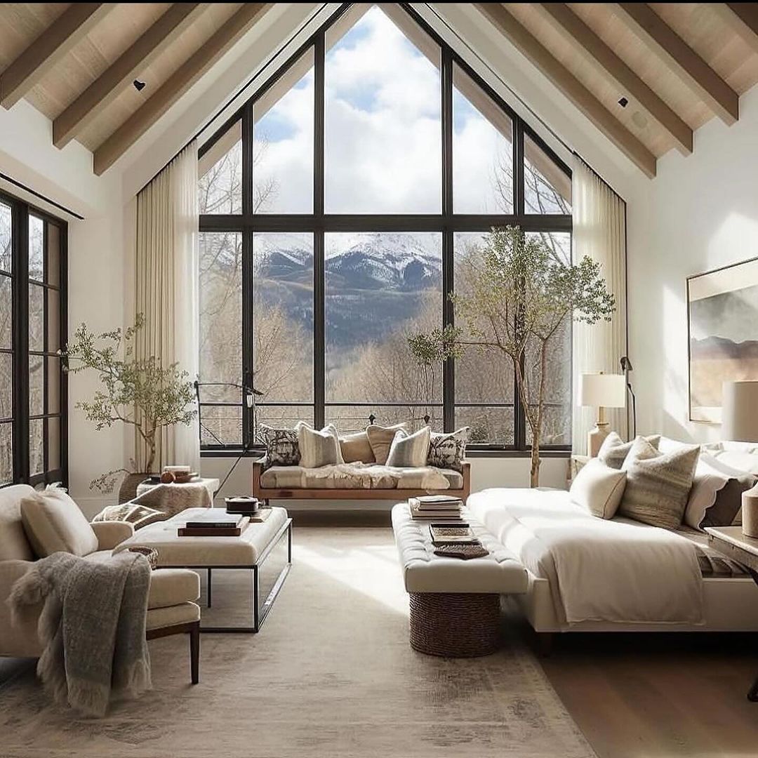 A pristine living room with floor-to-ceiling windows offering a panoramic view of snow-capped mountains