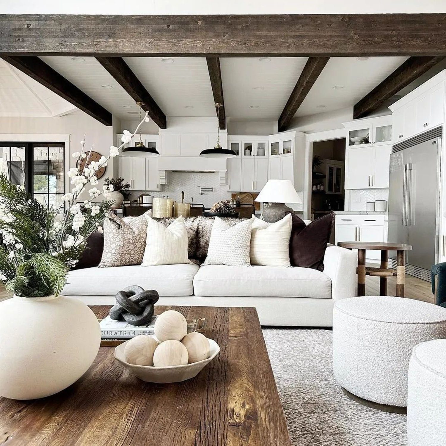 Elegant open-plan living space with exposed wooden beams and cozy neutral tones