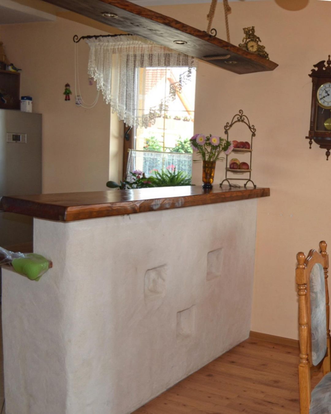 A quaint kitchen nook with a large window allowing natural light to accentuate the wooden countertop and vintage decor