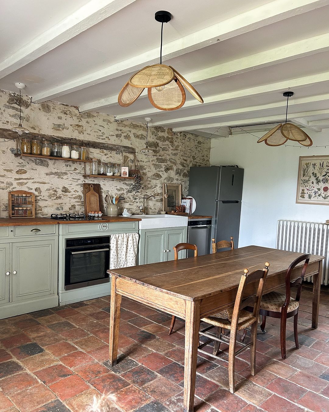 A quaint kitchen with a rustic charm featuring exposed stone walls and terracotta floor tiles