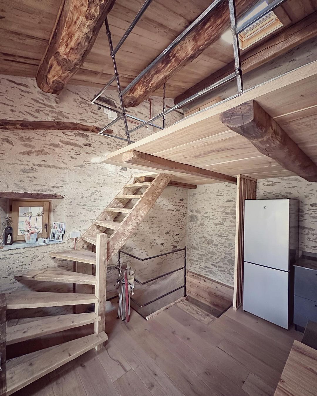 A rustic yet modern interior featuring raw wooden beams and a spiraling staircase