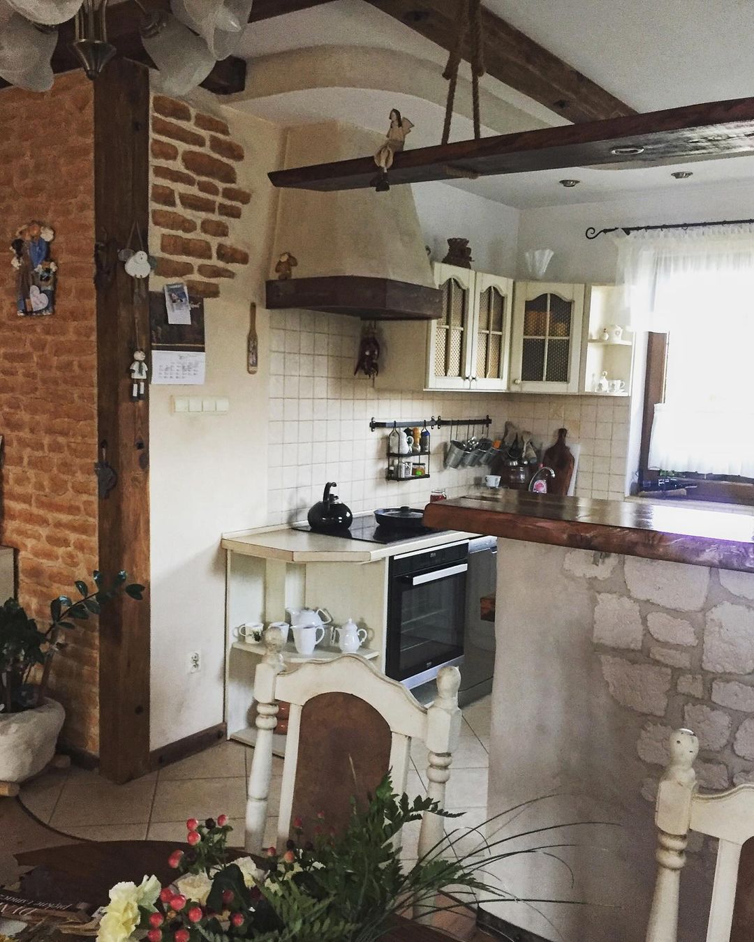 A cozy kitchen with rustic charm featuring exposed brick and wooden beams