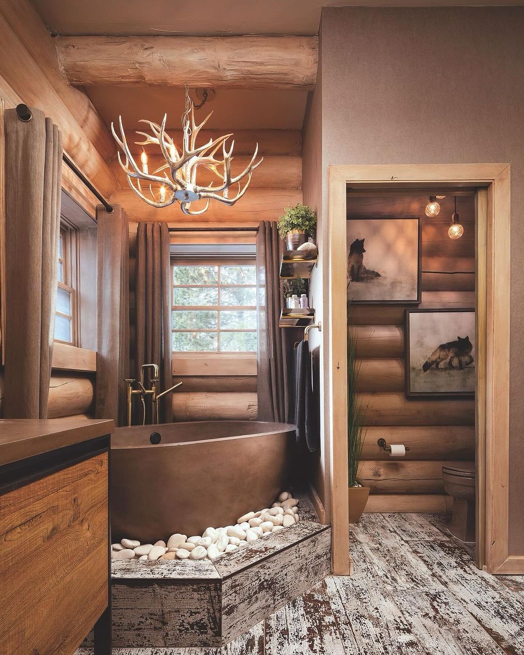 A cozy rustic bathroom featuring wooden elements and a unique antler chandelier