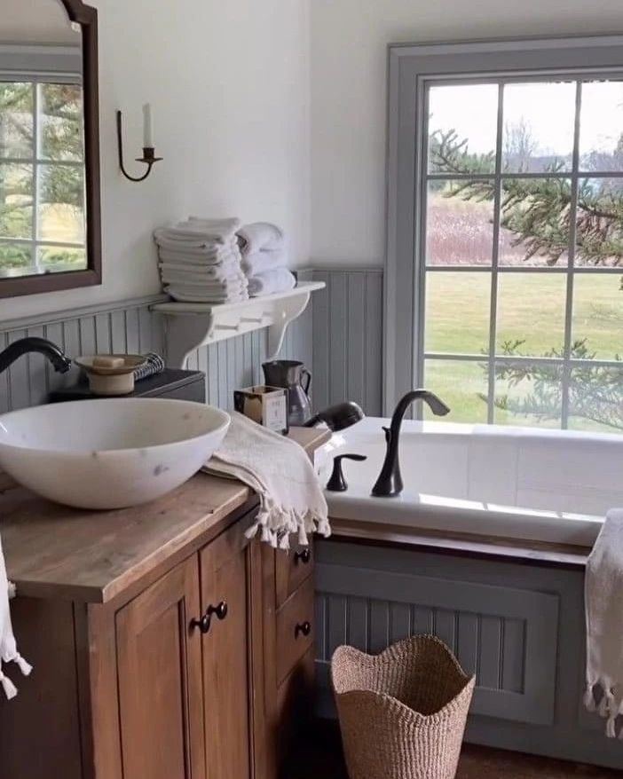 A cozy and rustic bathroom featuring a wooden cabinet with a vessel sink