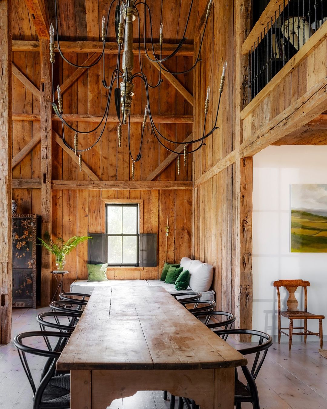 A rustic dining space with a long wooden table and metal chairs