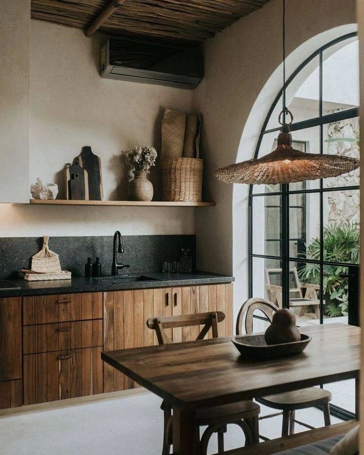 A rustic yet modern kitchen with wooden cabinets and a black countertop