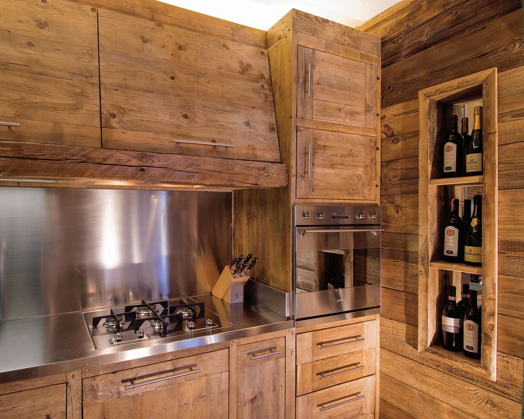 A rustic kitchen setup featuring rich wood cabinetry and stainless steel appliances