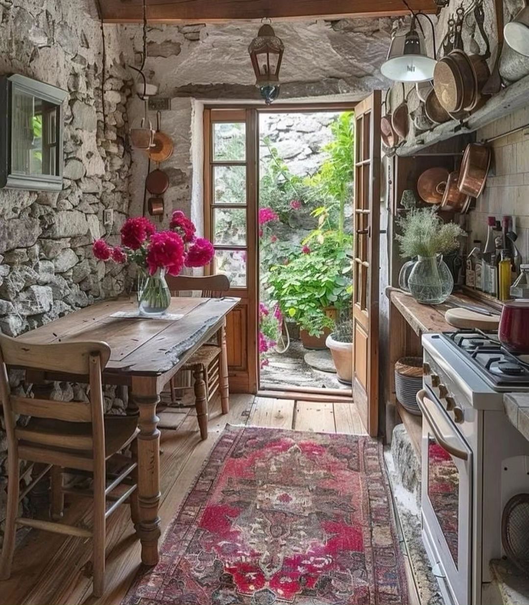 A cozy rustic kitchen with natural stone walls and a farmhouse-style wooden table