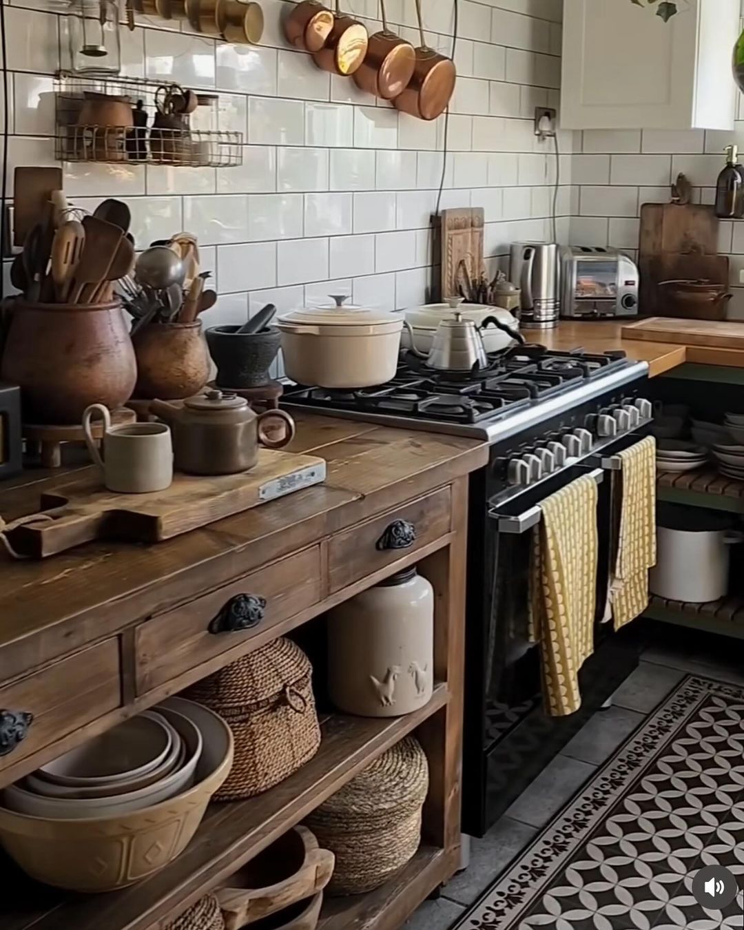 A cozy kitchen with a rustic charm featuring copper pots and a mix of wooden and ceramic utensils on open shelves.