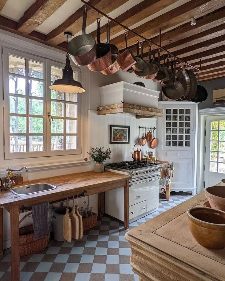 A rustic kitchen with exposed beams and copper pans