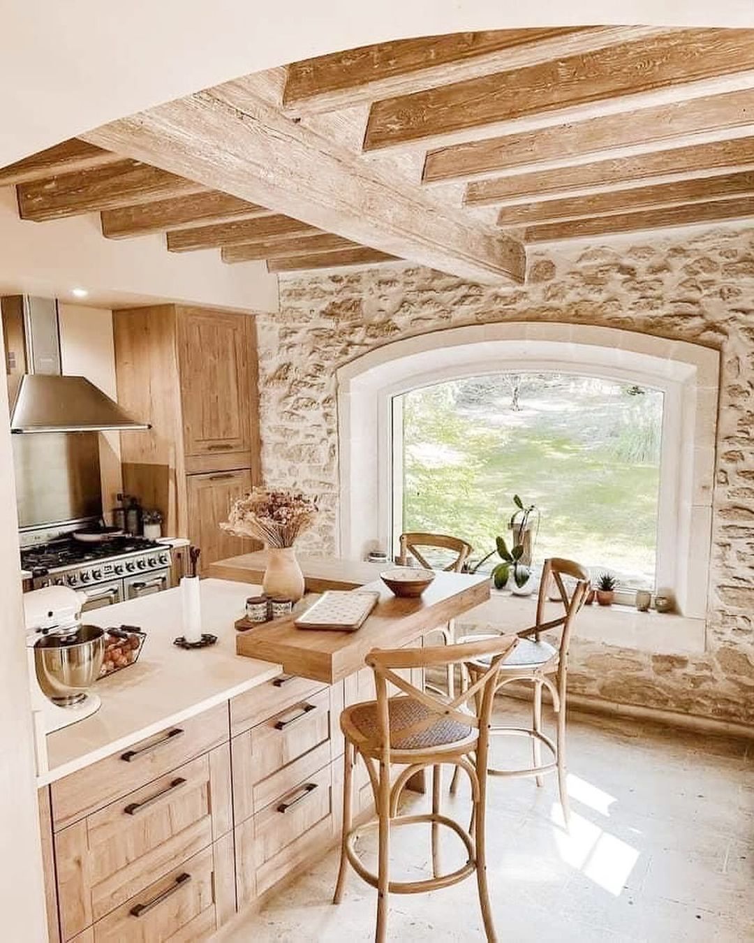 A rustic kitchen with an arched window