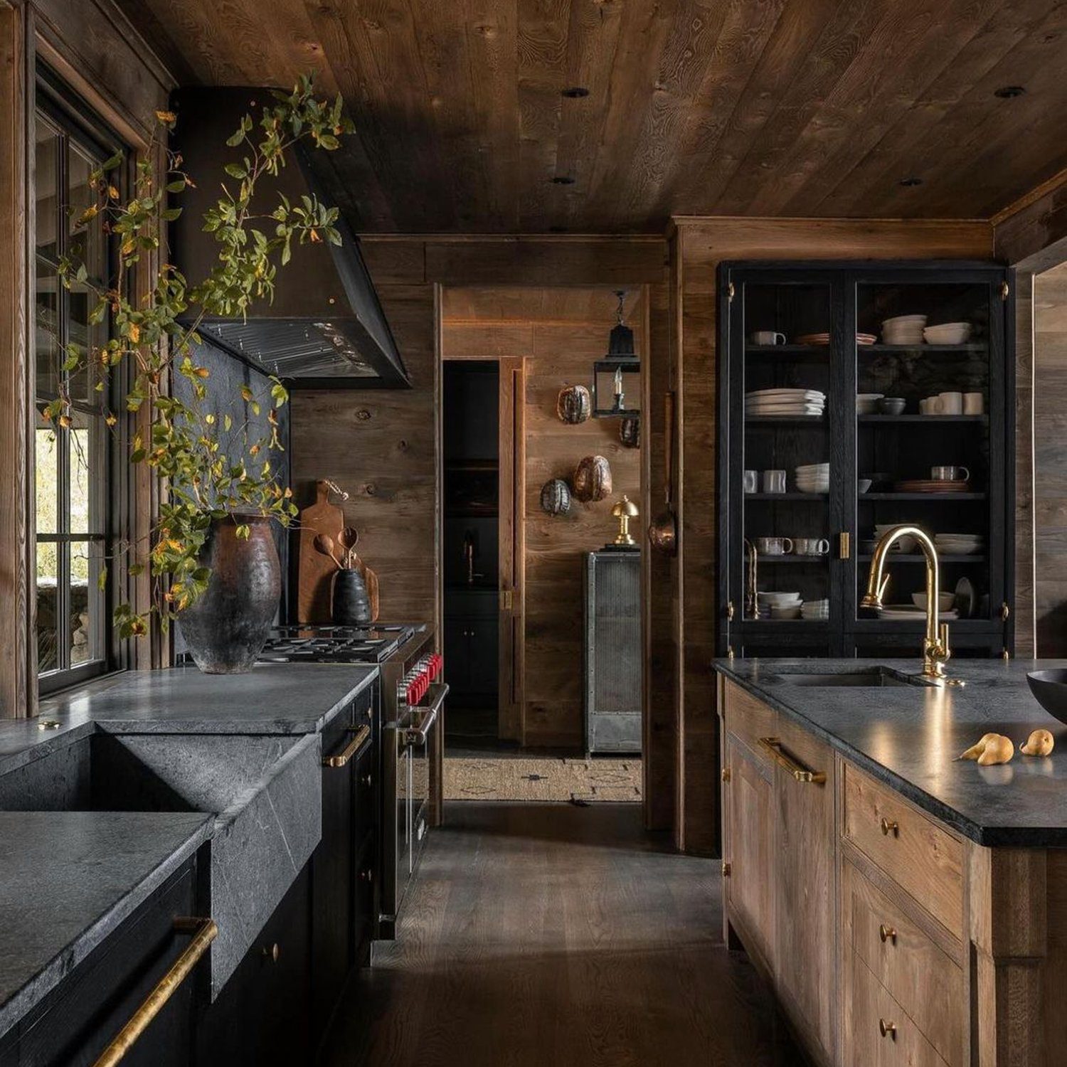 A rustic yet sophisticated kitchen featuring dark wood tones and black countertops