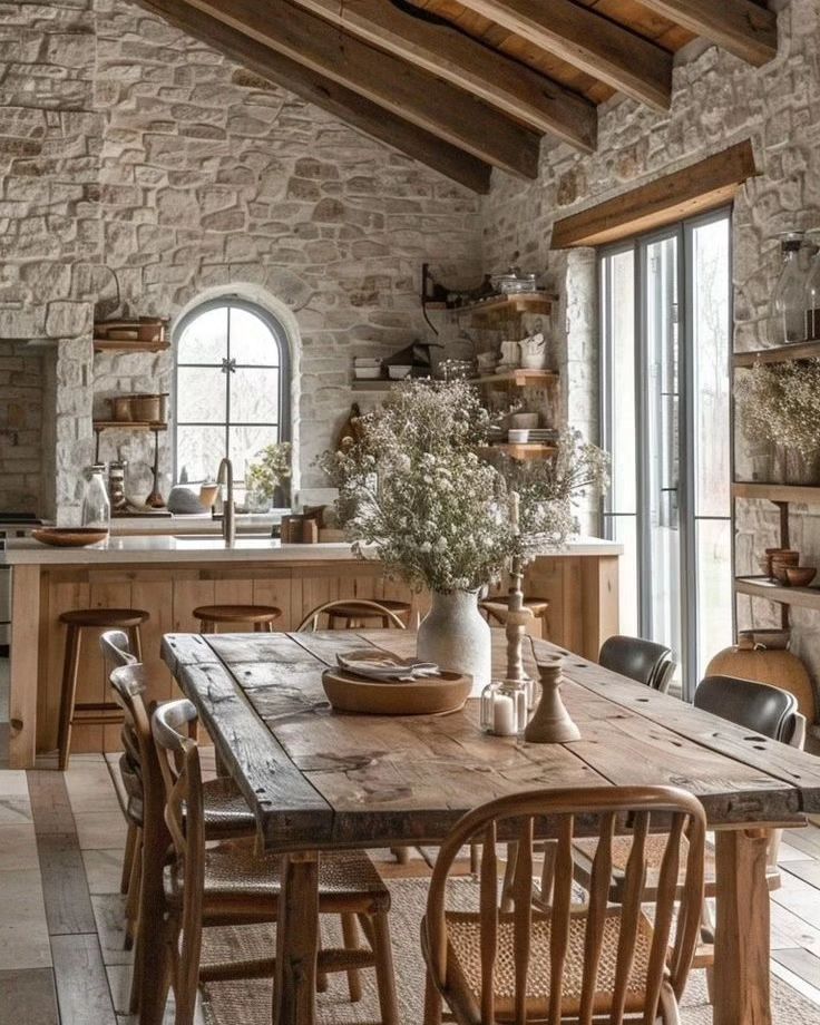 A rustic kitchen with exposed stone walls and wooden beams