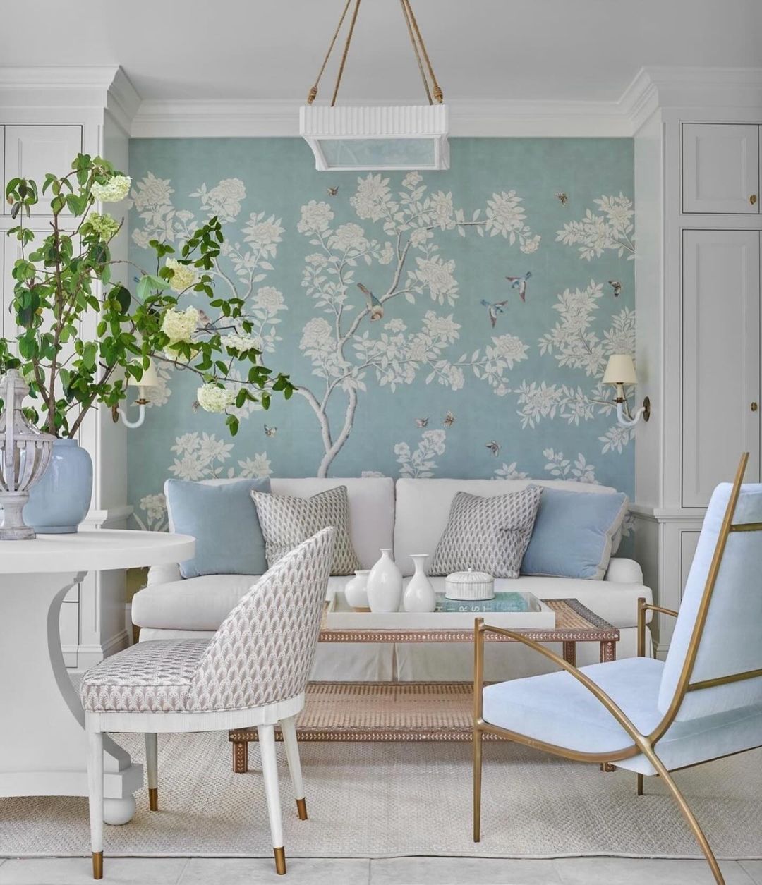 A serene and stylish living room design featuring a pastel blue floral wallpaper