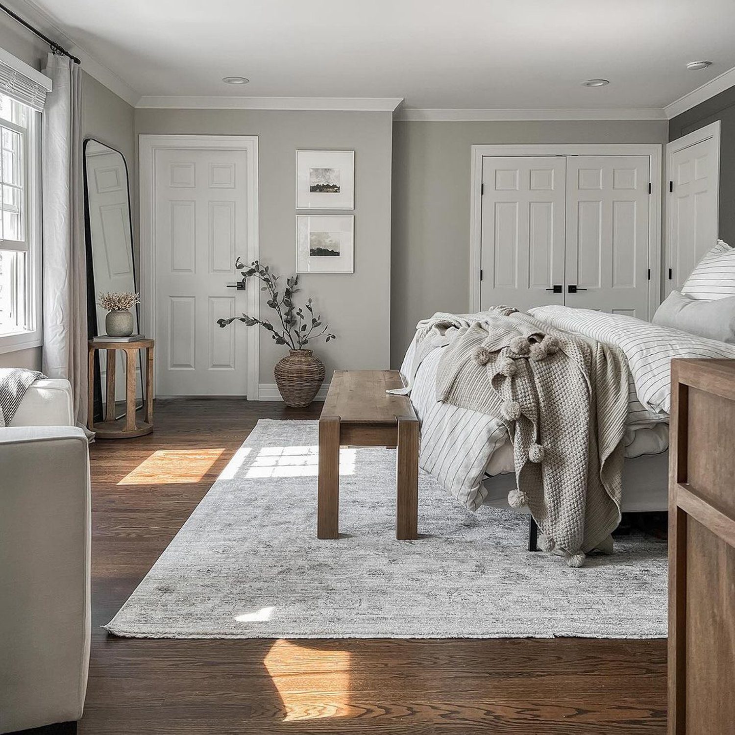 A serene bedroom setting with neutral tones and natural light