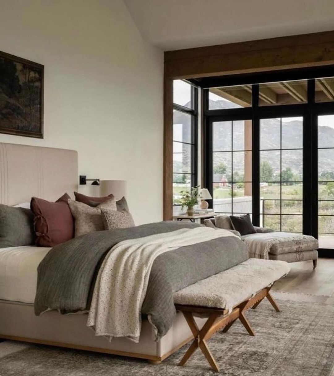 A serene bedroom with large windows offering a mountain view