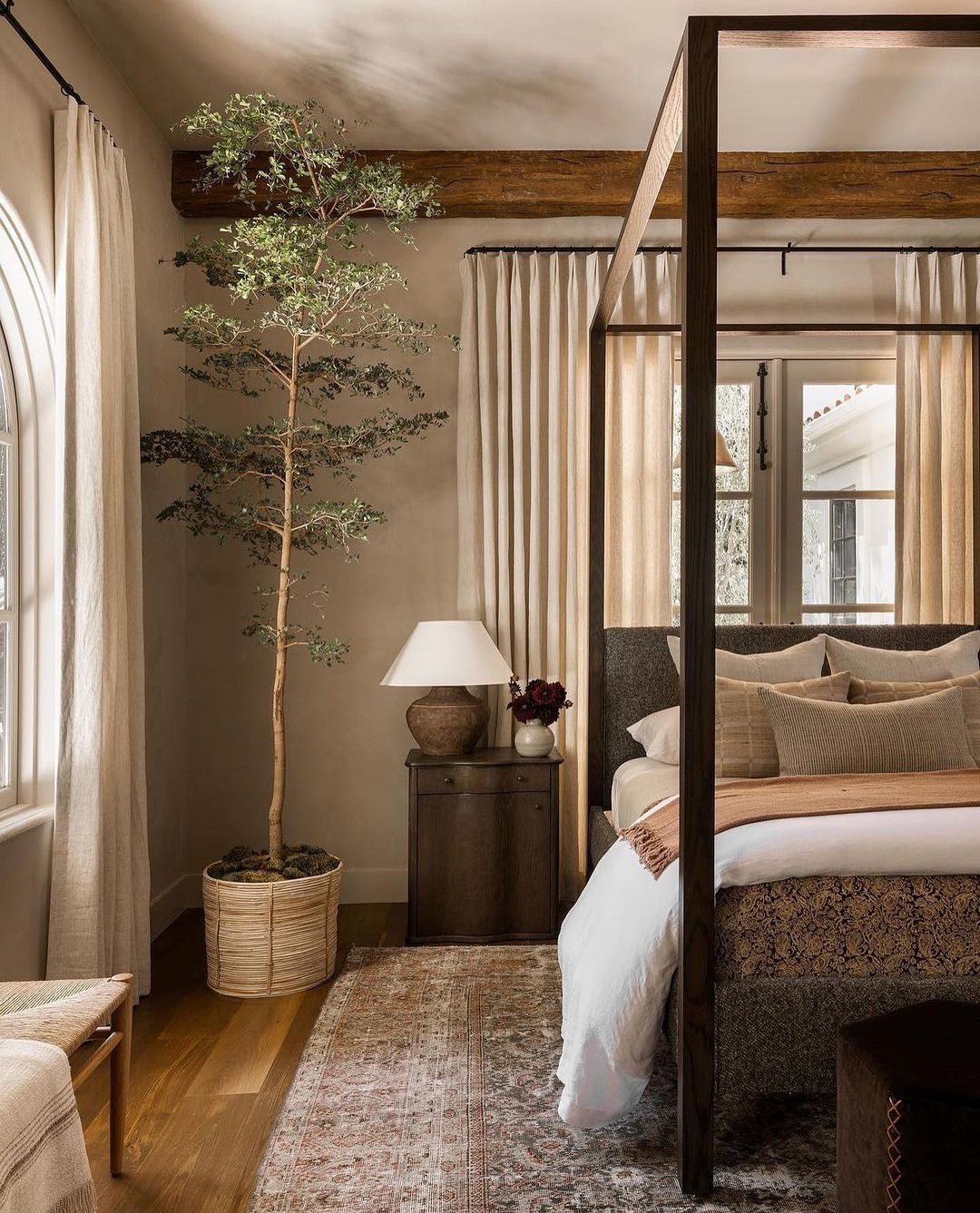 A serene bedroom design showcasing a rustic charm with a four-poster bed and earthy tones.