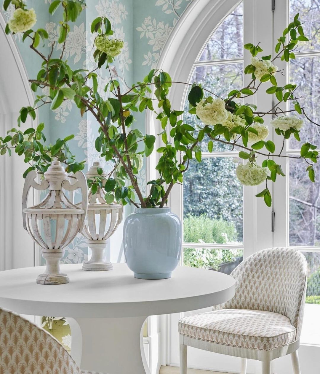 A serene and well-lit nook with arched windows overlooking a garden