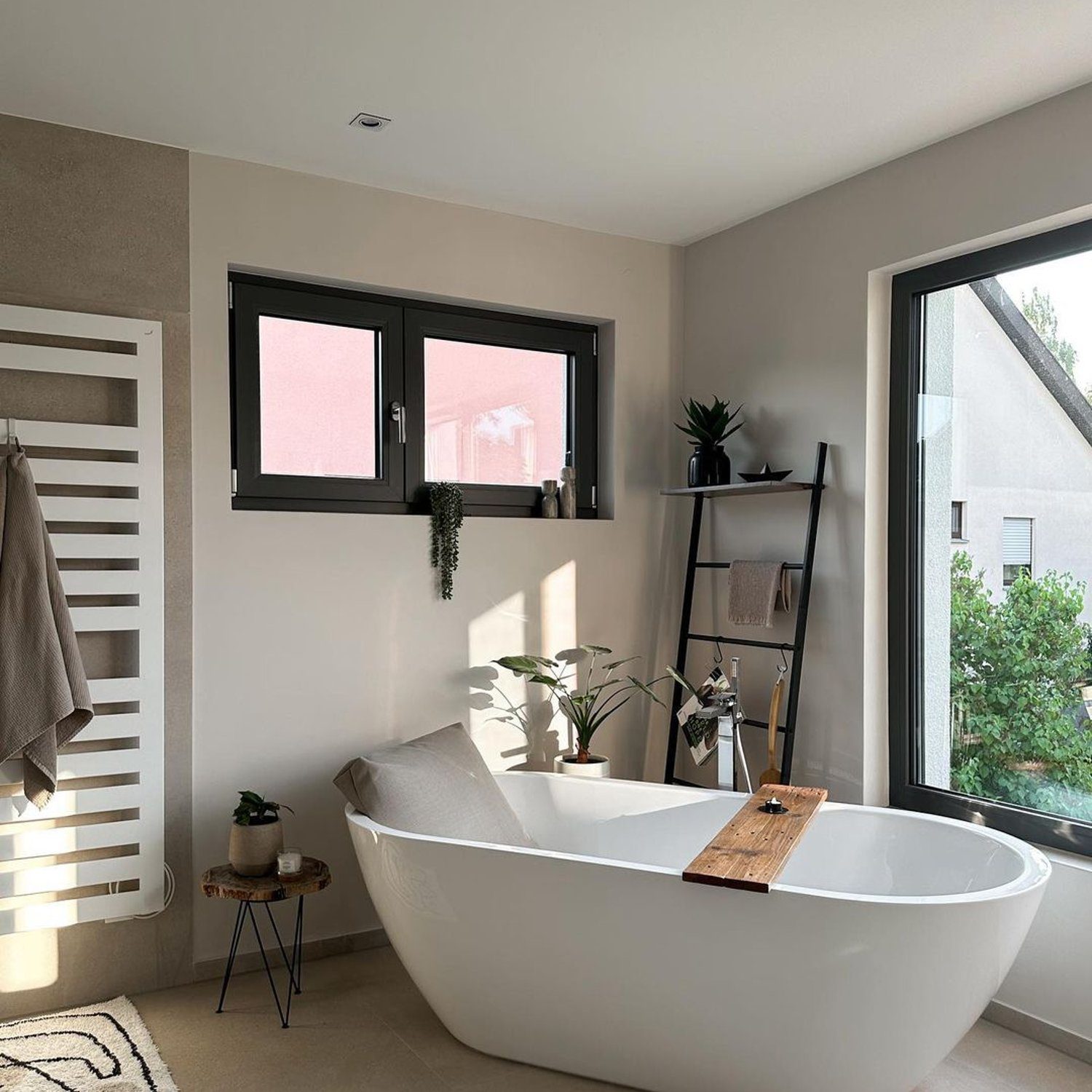 A serene and modern bathroom design with natural light bathing the freestanding tub