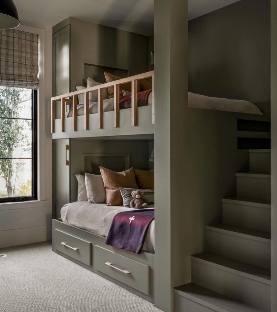 A compact and cleverly designed bunk bed nook with integrated storage and stair access