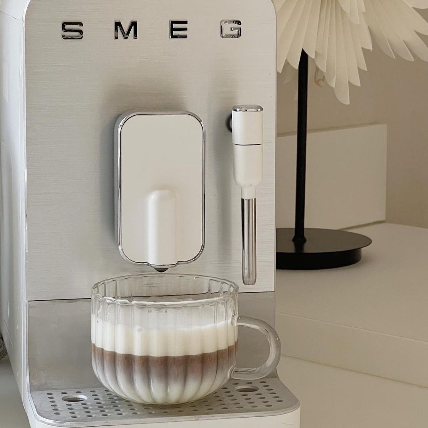 A sophisticated espresso machine with a cup of layered coffee