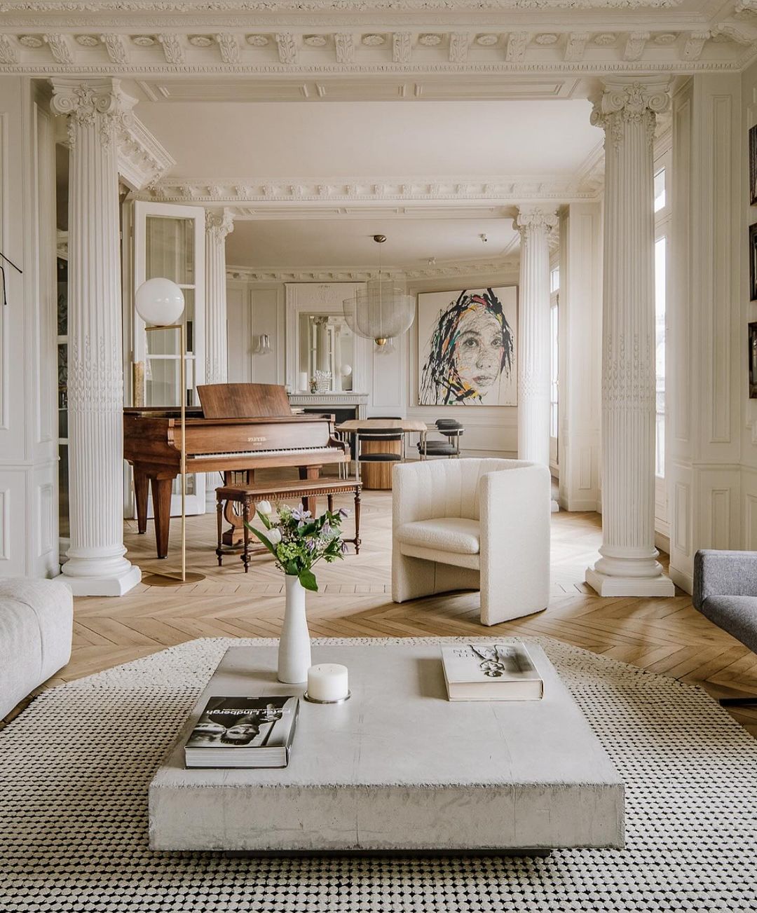 A chic and sophisticated living room featuring a grand piano and modern artwork