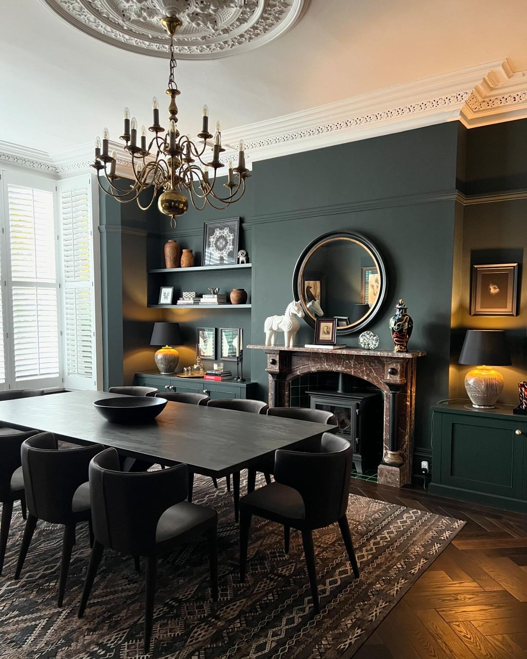 A sophisticated dining room with deep teal walls and classic molding