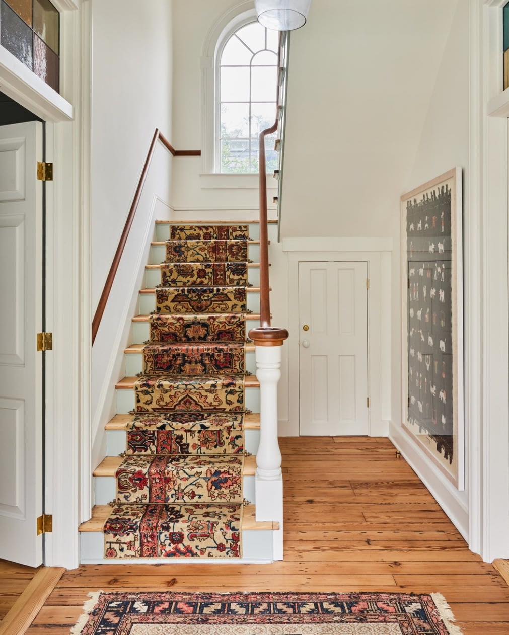 Classically styled staircase with a patterned carpet runner