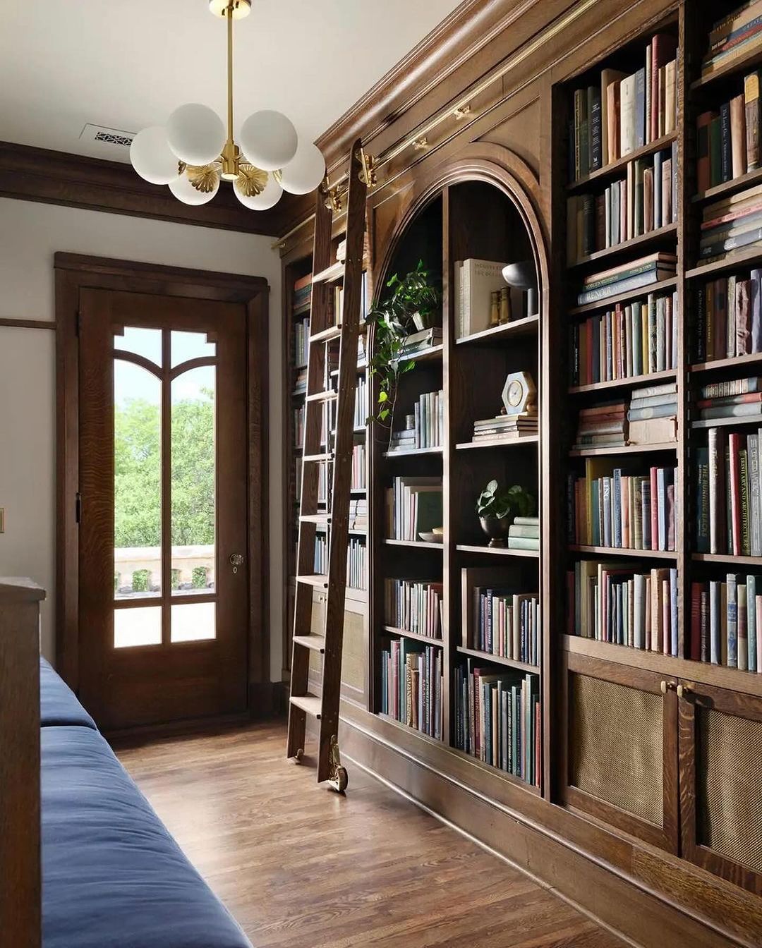 A stately home library with a classic wooden bookshelf and sliding ladder