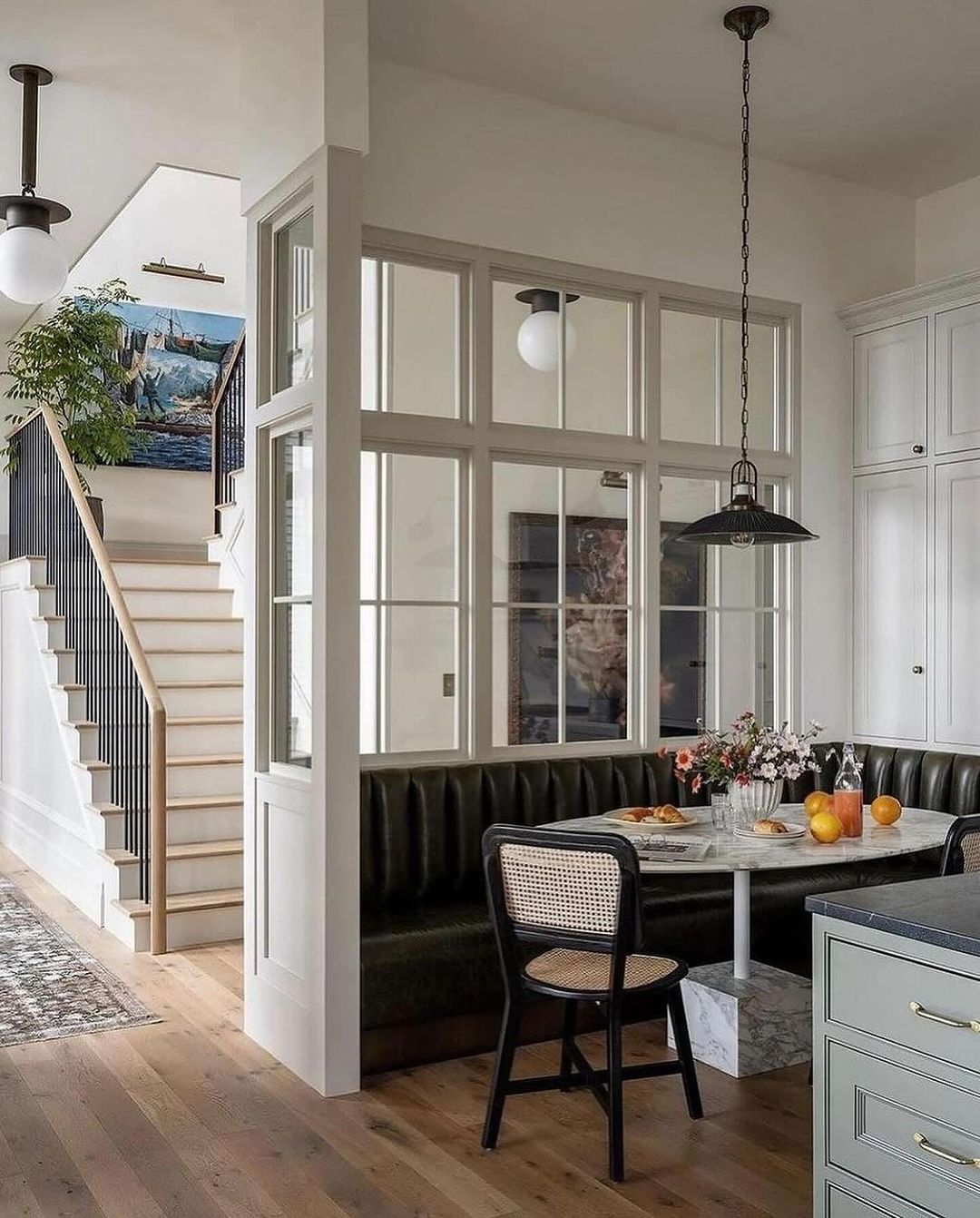 A chic dining nook featuring a plush olive green bench