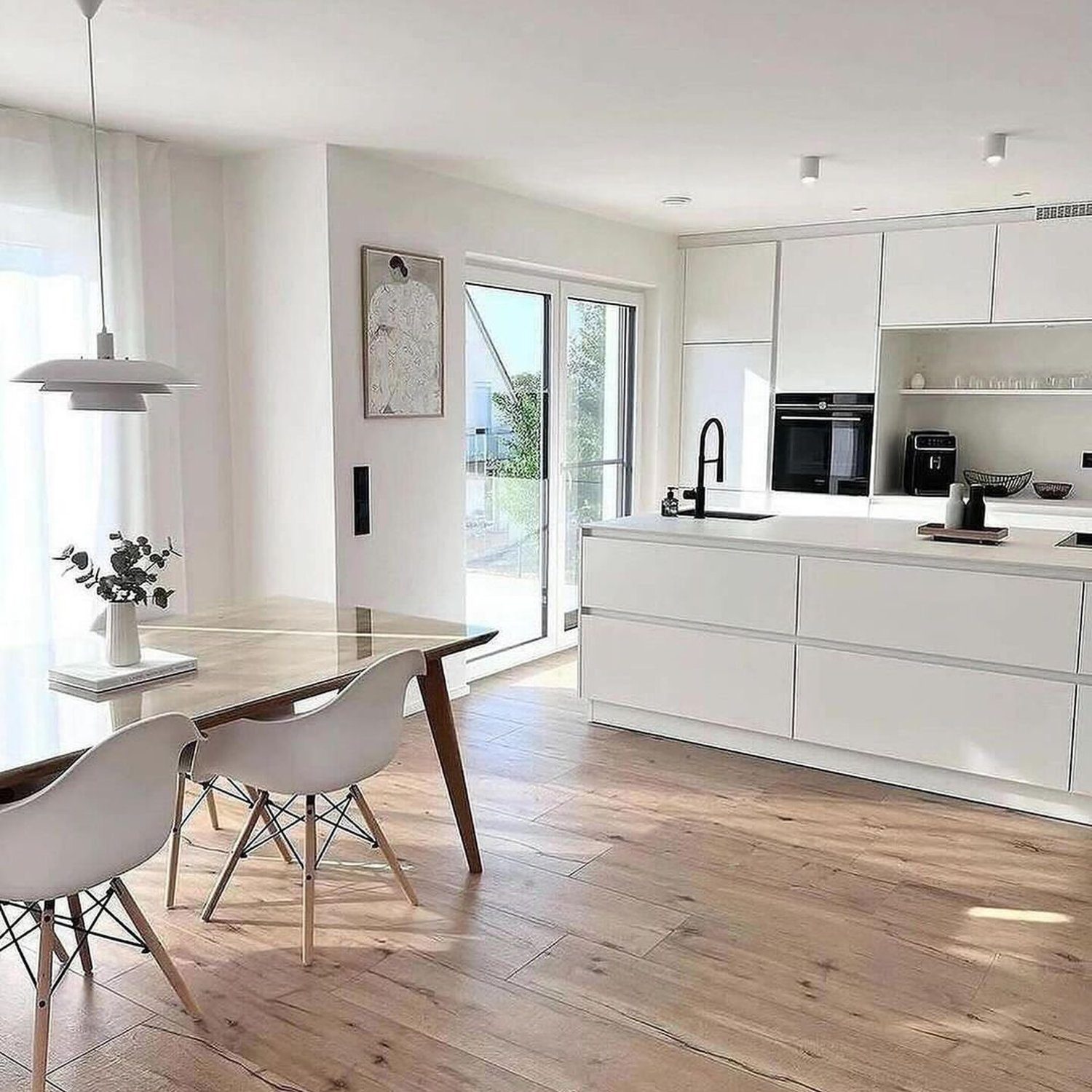 A modern minimalist kitchen with large windows and natural light