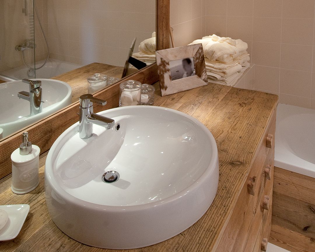 A modern bathroom featuring a rustic wooden countertop with dual white basin sinks