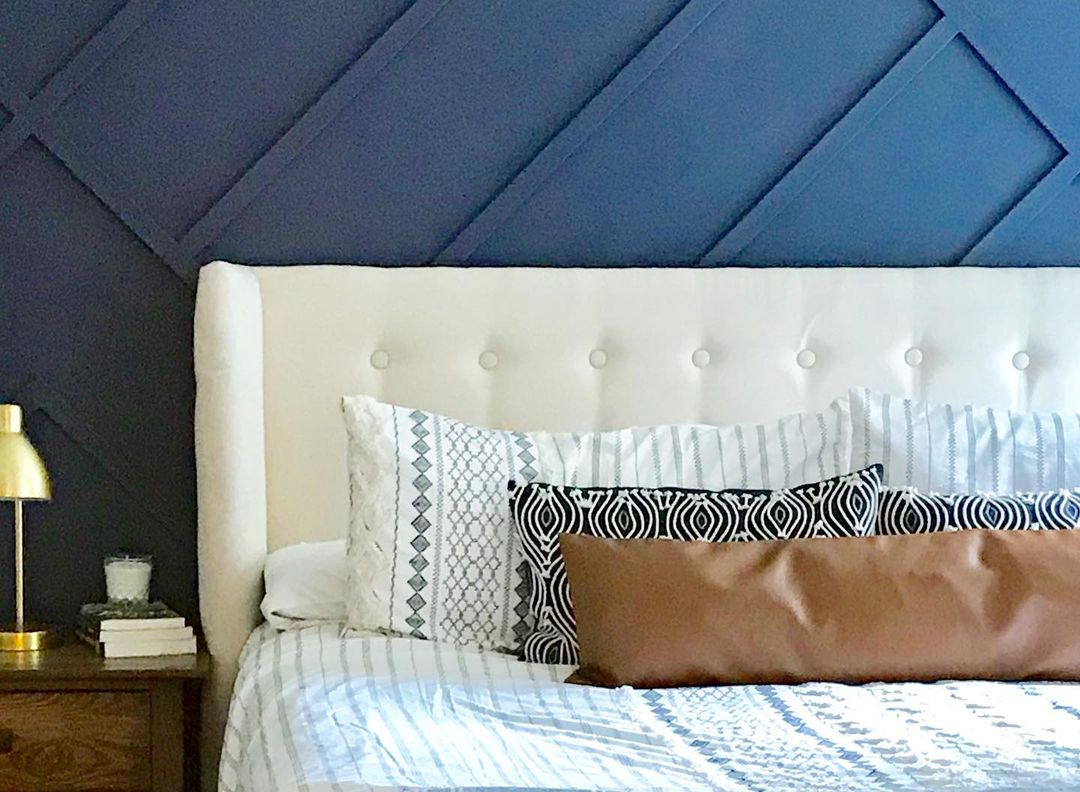 A chic and contemporary styled bedroom with a striking blue accent wall