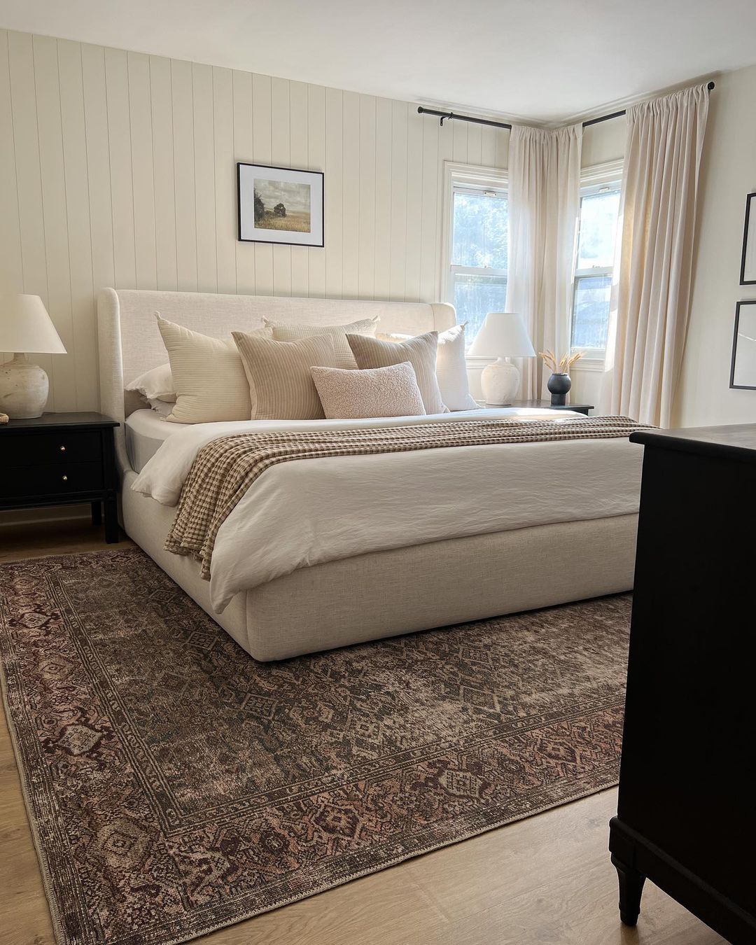 A tastefully designed bedroom featuring a large bed with plush beige linens